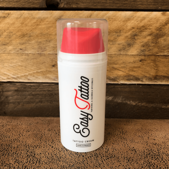 easy tattoo cream aftercare container with red cap on a wooden surface